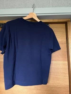 Mörkblå basically basics t-shirt från Gina Tricot stl XS - En enkel och stilren mörkblå t-shirt med rund hals och korta ärmar. Tillverkad i mjuk bomull som känns skön mot huden. Perfekt till jeans eller shorts för en clean look.
