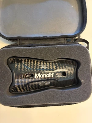Monolit benskydd i kolfiber - Säljer ett par Monolit benskydd i kolfiber med snyggt svart och grått mönster. Kommer i en praktisk och vadderad förvaringsväska. Lätta och tåliga, designade i Skandinavien för optimal passform och skydd under träning eller match.