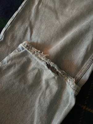 Ljusblå baggy jeans från sweet sktbs  - Säljer ett par ljusblå jeans med trendigt sliten och rå kant vid benslutet. Jeansen har en rak passform och klassisk femficksdesign. Perfekta för en avslappnad och cool stil. Materialet är kraftig denim. Dom är i storlek xxs men de passar som ett par riktigt baggy jeans i storlek S