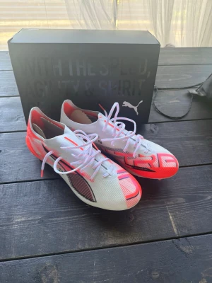Puma vita och röda fotbollsskor - Snygga fotbollsskor från Puma i vitt med röda och svarta detaljer. Helt oanvända!