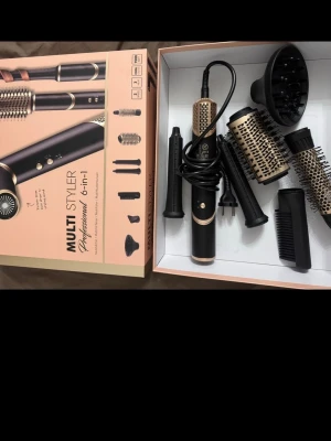 Multi Styler 6-i-1 hårstyler set - Säljer ett Multi Styler 6-i-1 hårstyler set med flera utbytbara borsthuvuden och tillbehör. Färgen är svart och guld, och materialet är plast och metall. Perfekt för att skapa olika frisyrer med både rundborste, volymmunstycke och locktillbehör. Från rusta. Bara testad🤍