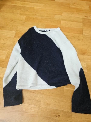 Stickad tröja Gina Tricot svart/vit - Säljer en stickad tröja från Gina Tricot i storlek 158/164. Tröjan har ett coolt grafiskt mönster i svart och vitt, rund halsringning och långa ärmar. Materialet är mjukt och mysigt, perfekt för kyligare dagar.