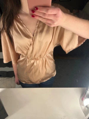 Topp - Omlottopp i satin🩷Den är mer rosa än på bilden men svårt att få fram. Man knäpper med dragkedja i ryggen. 