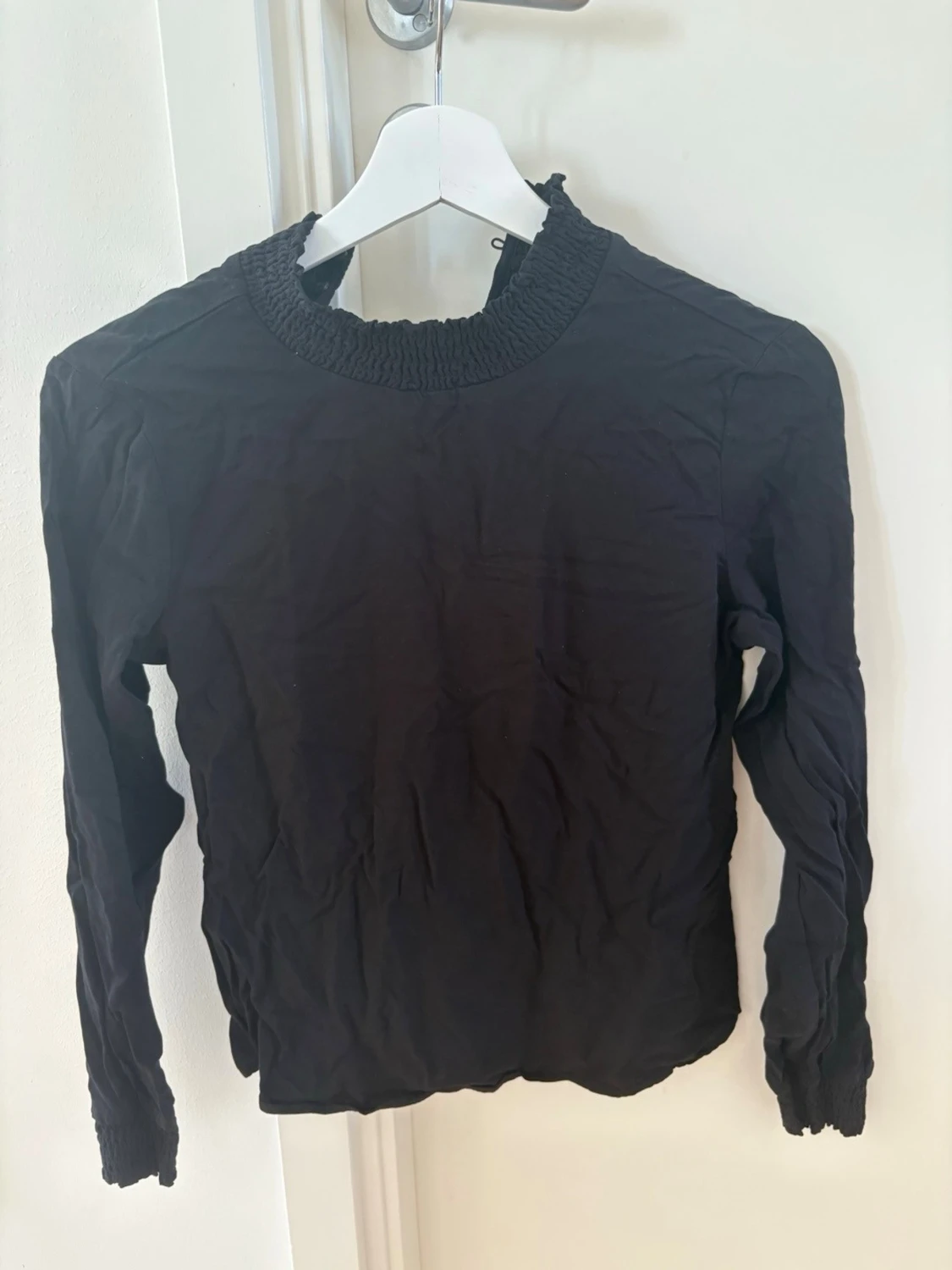 Svart blus med smockad krage