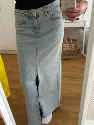Ljusblå lång jeanskjol med slits - Trendig ljusblå lång jeanskjol från na-kd, midjemått: 34cm, höjd: 92cm, helt oanvänd