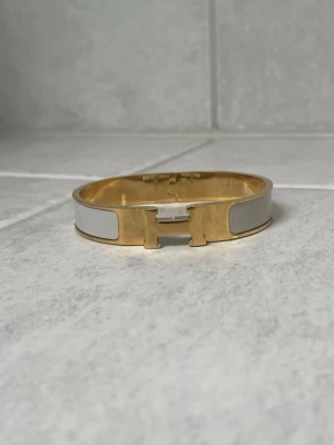 H armband - Snyggt armband i färgerna ljusgrå och guld. Armbandet är i mycket bra skick. Finns tyvärr inga tillbehör