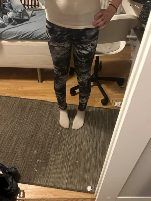 Svarta mönstrade leggings PX5 - Säljer ett par svarta leggings från PX5 Phelix Sports med coolt marmorerat mönster i vitt och grått. Tight passform och stretchigt material som sitter skönt. Perfekta till träning eller chill. Storlek 158/164.