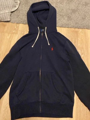 Ralph lauren zip hoodie  - Säljer för din har blivit för liten det är storlek S men funkar som XS också. Den har inga hål och är som ny. Äkta och köpt på kidsbrandstore. När jag köpte den var den lite liten så inte alls använd mycket!