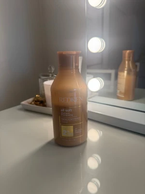 Redken All Soft schampo - Redken All Soft schampo i en guldig plastflaska. Schampot är speciellt framtaget för att ge mjukt och återfuktat hår och innehåller arganolja. 