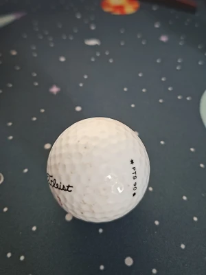 Vit golfboll från Titleist - Säljer en vit golfboll från Titleist med texten 'PTS 90' tryckt på sidan. Bollen har klassisk dimple-design och är tillverkad i slitstarkt material som passar perfekt för golfspelare som vill ha bra känsla och kontroll.