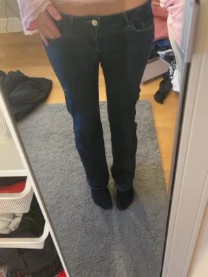 Mörkblå bootcut jeans - Säljer ett par mörkblå bootcut jeans med låg midja. Jeansen har en knapp och dragkedja framtill samt en läderpatch bak i midjan där det står ’ONLY’ Perfekta för dig som gillar lågmidjade jeans! St XS men passar även S. Leg 34. Säljer pga dom bara ligger i min garderob💕 