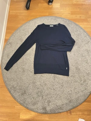 Mörkblå stickad tröja Jack & Jones - Tunn mörkblå stickad tröja från Jack & Jones. perfekt till vår/sommar!