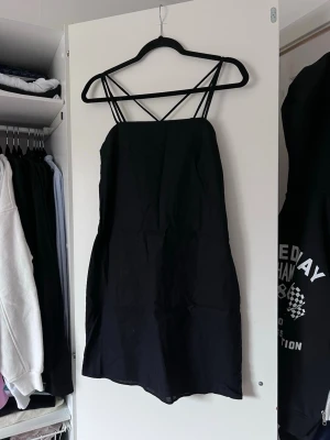 Svart linneklänning med smala axelband (NY)  - Svart linneklänning från H&M med smala korsade axelband och dragkedja på sidan. Stilren look 🖤 Prislapp kvar, aldrig använd!