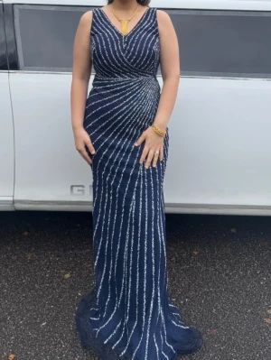 Marinblå långklänning med glitter - Snygg marinblå långklänning med v-ringning. Storleken är L men passar bra till M också💖 hör av dig om du vill ha flera bilder.