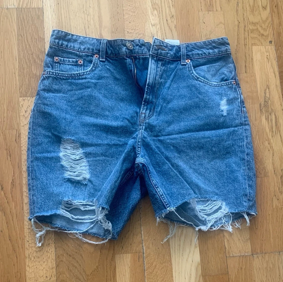 Blå jeansshorts med slitningar