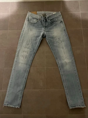 Dondup George W30 - Säljer ett par ljusblå jeans med slitningar och råa kanter vid bensluten. Jeansen är skinny fit och har smal och rak passform. Tillverkade i denim med snygg tvättad look. Hör av dig vid minsta lilla fundering, eller prisförslag.