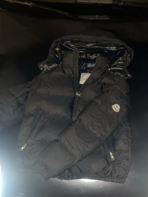 Svart Moncler dunjacka med huva - Svart moncler jacka fint skick nästan aldrig använd av mig säljer för den är för liten för mig lite dåliga bilder men bara hör av er för mer eller bättre bilder 