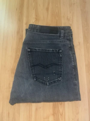 Repaly jeans  - Mörkgråa jeans från Replay, modell Marty med slitningar och hål. Jeansens tyg är gjort i Organic Cotton som gör att dem upplevs sköna och bekväma. Midja 39cm, längd 102cm. JAG SKICKAR EJ FLER BILDER NÄR JAG BÄR JEANSEN! för bättre inblick i passformen rekommenderar jag att googla på modellnamnet. För storleksguide kolla måtten noggrant då jeansen alltid kan vara uppsydda heller krympta och jag ej tar emot returer :) s6,4