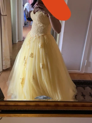 Gul baklänningmed spetsdetaljer - Säljer en fantastisk gul balklänning med vackra spetsdetaljer och blommiga applikationer . Perfekt för bal! Säljer då jag hittat en annan klänning, endast testad, storlek 36/S❤️pris kan diskuteras