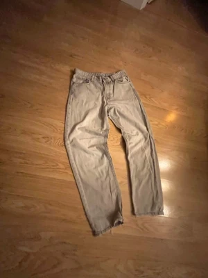 Beige raka jeans med fem fickor - Säljer ett par Brå jeans med rak passform och klassisk femficksdesign. Jeansen har normal midja och är tillverkade i ett mjukt denimtyg. Perfekta för en avslappnad och stilren look.