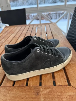 Svarta låga sneakers med mocka - Snygga grön/grå/svart kan inte riktigt avgöra vad de är för färg Hahah, i mocka med grått tåparti i läder och vita sulor. Klassisk design med svarta skosnören och metallöljetter. Passar perfekt till jeans eller streetwear och ger en clean look. 