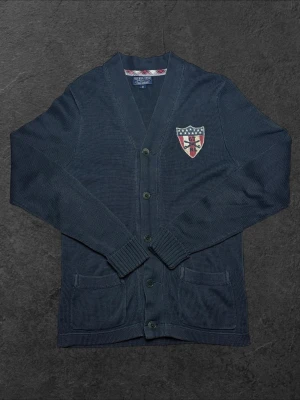 Ralph Lauren Vintage kofta -herr strl M - Säljer en vintage Ralph Lauren kofta i mörkblå färg i storlek M med broderad sköld på bröstet  👕 Märke: Ralph Lauren 📏 Storlek: M 🎨 Färg: Mörkblå 📍 Skick: Mycket bra skick (se bilder)  💬 Har du några frågor är det bara att höra av dig! 💰 Vid snabb affär kan priset diskuteras. 📦 Skickar alltid inom 24 timmar!