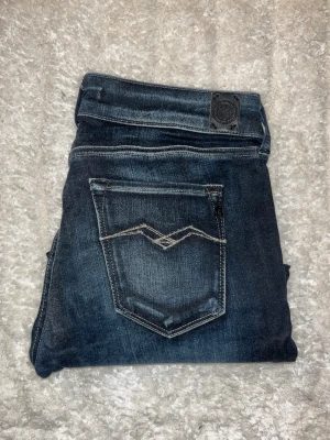 Repaly jeans  - Mörkblåa jeans från replay med snygg fade med en tajt passform.Midja 36cm, längd 100cm. Obs tyget är lite förtunnat baktill och fram längst ned vid gylfen - se bild. Storlekslapp saknas men jag uppskattar till W27 L30 - men utgå alltid efter mått. JAG SKICKAR EJ FLER BILDER NÄR JAG BÄR JEANSEN! för bättre inblick i passformen rekommenderar jag att googla på modellnamnet. För storleksguide kolla måtten noggrant då jeansen alltid kan vara uppsydda heller krympta och jag ej tar emot returer :) s6,4