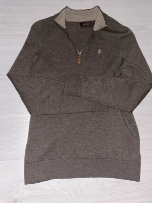 Brun halvzip-tröja från Morris - Snygg brun stickad tröja från Morris med halvzip och ribbade muddar. Tröjan har en liten broderad logga på bröstet och kontrastfärgad insida på kragen. Perfekt till lager på lager och enkel att matcha.   Tröjan passar perfekt till en som har storlek XS, då den har krymt från M som du kan se på sista bilden.  Hör gärna av dig om minsta fundering, jag finns här till hjälp. Priset kan minskas🙂 