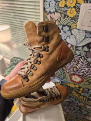 Bianco födrade läder vinterkängor, Brun/ beige, Storlek 37 - Säljer ett par snygga höga kängor i brunt läder med beige textilpartier och robust snörning med metallhakar. Kängorna har en klassisk outdoor-look och slitstark sula, perfekta för dig som gillar en avslappnad men cool stil.