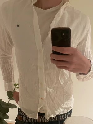 Vit skjorta från Morris Stockholm - Klassisk vit skjorta från Morris Stockholm i storlek M (39/40). Skjortan har lång ärm, knappar framtill och en liten broderad logga på bröstet. Tillverkad i bomull och passar perfekt till både jeans och chinos.