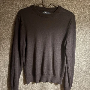 Mörkblå stickad tröja från Riley (merinoull) - Klassisk mörkblå stickad tröja från Riley med rund halsringning och långa ärmar. Tröjan har ribbade muddar vid ärmslut och nederkant, vilket ger en snygg och enkel look. Perfekt att matcha med jeans. Tröjan är i storlek S men skulle säga att den passar nån stans mellan xs och S.