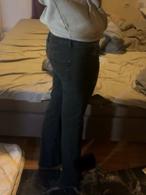 Svarta lågmidjade bootcut jeans - Säljer ett par svarta bootcut jeans med klassisk femficksdesign och hög midja. Jeansen har en snygg passform som sitter tajt upptill och släpper ut vid benen. Perfekta för dig som gillar en stilren och enkel look. Jeansen passar både dig som har M och L enligt mig. Pris kan diskuteras🥰