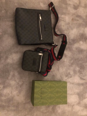 Två gucci väskor - Den stora Gucci väskan är äkta fast har inte kvitto eller paket med, men säljer den för 2000 kr med bra skick och har använt den 4-5 gånger .                                                                                     Den lilla Gucci väskan är en kopia men är i bra skick och oanvänd. Kommer med paket och säljer den för 1100 kr.        Säljer båda för 3100 kr men om man köper båda kan säljas för 2800