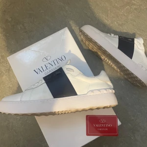 Valentino Garavani vita sneakers med mörkblå detalj - Säljer skor från Valentino Garavani. Dem var lite för stora för mig. Använda ett par gånger, men är i bra skick. Klassisk och stilren design, fetaste du kan köpa inför sommaren. Priset är inte hugget i sten. Kan gå ner i pris, vid snabb affär. Kvitto finns. Behöver pengar jätte akut