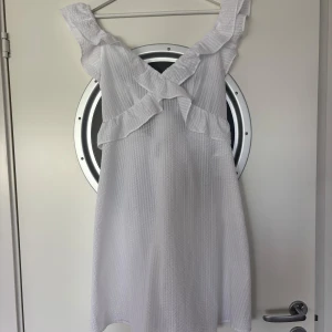 Vit volangklänning från Vero Moda - Superfin, enkel och perfekt studentklänning från Vero Moda med volangdetaljer och knytning i ryggen. Passar också perfekt till andra sommarhögtider som till exempel midsommar💞💞
