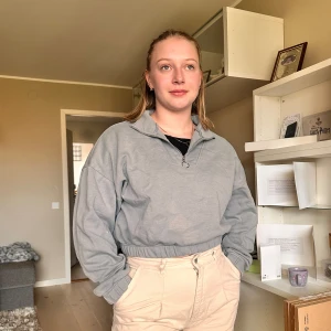 Ljusgrå croppad sweatshirt med dragkedja - Säljer en ljusgrå croppad sweatshirt med halv dragkedja i halsen och resår i midjan. Tröjan har lång ärm och en avslappnad passform, perfekt för en chill och stilren look.