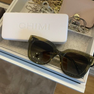 Gröna solglasögon från CHIMI - Stilrena solglasögon från CHIMI i en transparent grön färg. Modellen har breda bågar och stora, fyrkantiga glas. Dom är använda ett fåtal gånger men ser fortfarande ut som nya, inga defekter. Perfekta nu till våren och sommaren. Glasögonfodral och skyddspåse tillkommer!💗