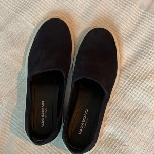 Marin blå slip ons från vagabond - Ett par fräsa vagabond slippers som vill komma ut på gatorna igen dom är anävda få gånger i sommras då dom var lite stora på mig nu pris 1200 storlek 41 rekommenderar att gå ner en storlek 