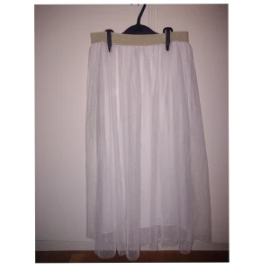 Vit långkjol med glittrig resår✨ - Vit långkjol från Kappahl med glittrig guldresår i midjan. Kjolen har en mjuk underkjol och ett skirt yttertyg som ger en drömmig känsla. Perfekt till sommaren eller till speciella tillfällen! 💗 Tveka inte att kontakta mig vid frågor/fler bilder! :)