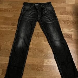 Svarta jeansbyxor från Verri - Säljer ett par svarta jeansbyxor från Verri med vita kontrastsömmar och snygga detaljer på bakfickorna. Klassisk femficksmodell med knapp och dragkedja i gylfen. Perfekta för dig som gillar stilrena och tidlösa jeans. Jätte fint skick. Postar direkt. Skriv vid frågor!