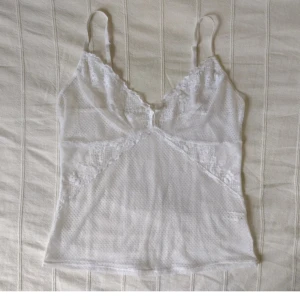 Vitt see through spetslinne - vit topp/linne  - Vitt spetslinne i storlek M 40/42. See through med snygga detaljer och smala axelband.