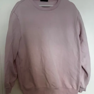 Ljusrosa crewneck sweatshirt från H&M - Säljer en ljusrosa crewneck sweatshirt från H&M i relaxed fit. Tröjan har rund halsringning och långa ärmar, perfekt för en avslappnad stil. Tillverkad i mjuk bomullsmix för extra komfort.