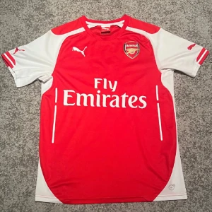 Arsenal hemmatröja 2014/15 - Säljer denna Arsenal hemmatröja från säsongen 2014/15. Den är bra i skick som syns på bilderna. Hör av dig vid frågor!