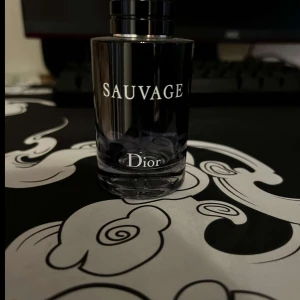 Sauvage herrparfym från Dior - Säljer en elegant herrparfym från Dior, modellen Sauvage. Flaskan är cylindrisk i glas med svart och silverdetaljer. Doften är fräsch och maskulin, perfekt för dig som gillar exklusiva parfymer.