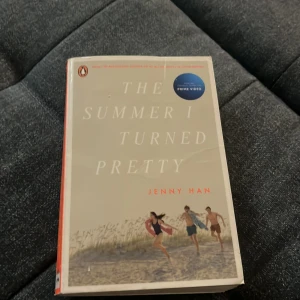 The Summer I Turned Pretty - Säljer boken 'The Summer I Turned Pretty' av Jenny Han. Pocketbok på engelska med ett somrigt omslag där tre ungdomar springer på stranden. Perfekt för dig som gillar romantik och ungdomslitteratur. Utgiven av Penguin Books.