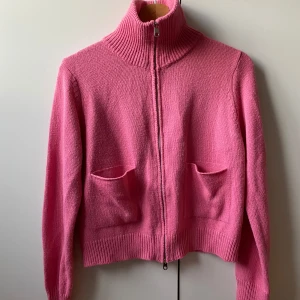 Rosa stickad kofta med dragkedja - Säljer en rosa stickad kofta med hög krage och dragkedja framtill. Koftan har två fickor på framsidan och ribbade muddar vid ärmslut och nederkant. Perfekt för lager-på-lager och en färgklick i garderoben. Från Shein💕