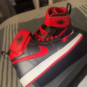 Nike Air Jordans svart och röd - Säljer ett par Nike Air Jordans i svart och rött med klassisk hög modell. Skorna har röd swoosh, röda snören och detaljer samt svart bas. 🤩