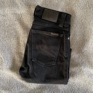 Svarta Nudie Jeans - Säljer dessa riktigt feta Nudie jeans i färgen svart! 🙌 Storlek = L32/W26 | Skick = 9/10 | Nypris över 1500kr, mitt pris = 299kr! 🙌 Jeansen har inga deffekter! Hör av er vid minsta fråga eller fundering! ⭐️