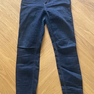 Mörkblå jeansbyxor från Acne Studios - Säljer ett par mörkblå jeansbyxor från Acne Studios i modellen SKIN 5 RW RINSE. Byxorna har smal passform och är tillverkade i bomull med lite stretch. Klassisk femficksdesign. 