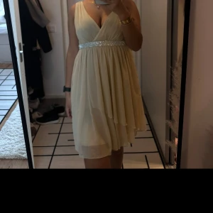 Champagnefärgad klänning med glittrigt midjeband - Klänning från Saint Tropez, storlek S, pris 100 kr.